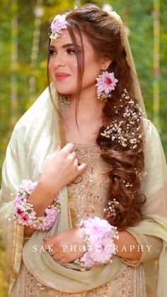 a woman with long hair and flowers in her hair is posing for the camera while wearing a