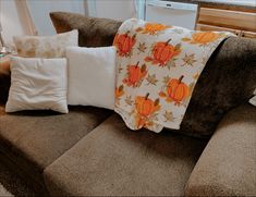 a couch with pillows and pumpkins on it