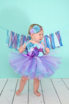 *Please check turn around times. All items are made to order* This listing is for an Under the Sea Birthday Tutu Dress that is simply stunning. Made with purple, lavender, and turquoise tulle. Bodice is adorned with multiple styles of different colored flowers to match. Comes with turquoise satin straps that ties over the shoulders in a pretty bow. Headband and banner is not included but can be purchased from my shop. Link to Banner - https://www.etsy.com/listing/232018738/purple-and-blue-fabric Purple Summer Birthday Dress, Purple Sleeveless Dress For Birthday, Cute Blue Tutu Dress For First Birthday, Purple Sleeveless Tutu Dress For Birthdays, Purple Sleeveless Tutu Dress For Birthday, Blue Tulle Dress For First Birthday, Cute Purple Tutu Dress For First Birthday, Purple Cute Tutu Dress For First Birthday, Playful Purple Princess Dress For Summer