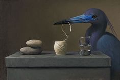 a blue bird sitting on top of a table next to rocks and a glass filled with water