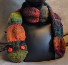 a knitted hat and scarf on a mannequin's head with buttons