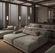 a living room filled with lots of couches and windows covered in shades of grey