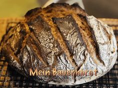 a loaf of bread sitting on top of a cooling rack with the words mein bautenhrott