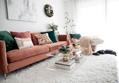 a living room filled with lots of furniture and decor on top of a white rug