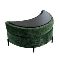 a green velvet bench with black metal legs and an oval shaped seat on the back