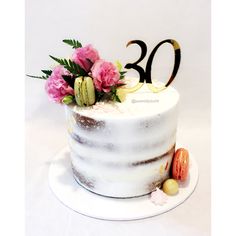 a white cake with pink flowers on top and the number twenty two is decorated in gold