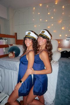 two beautiful young women in sailor hats posing for the camera