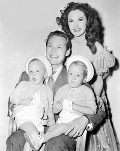 an old black and white photo of three people with two babies