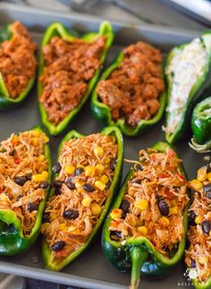 green peppers stuffed with shredded meat and vegetables on a baking sheet, ready to be cooked