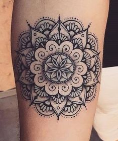 a woman's leg with a tattoo on it that has an intricate flower design