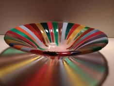 a multicolored glass bowl sitting on top of a table