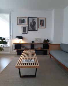 a living room filled with furniture and framed pictures on the wall above a coffee table