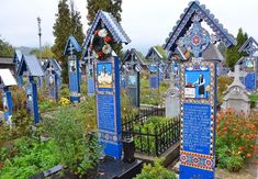 a cemetery with many blue crosses and flowers growing in it's garden area,