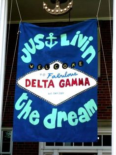 a blue banner hanging from the side of a building that says, just & livi welcome to fabulous delta gama