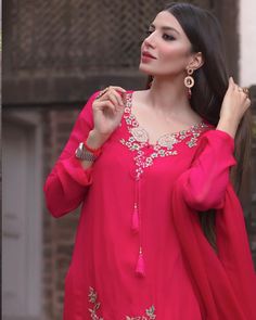 a woman in a red dress is posing for the camera with her hand on her hip