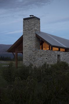 a stone building with a metal roof at dusk