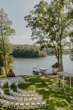 an outdoor ceremony set up on the lawn by the water with chairs and gazebo