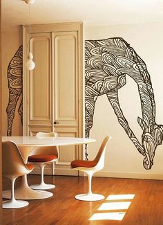 a dining room with an artistic wall decal in the shape of a giraffe