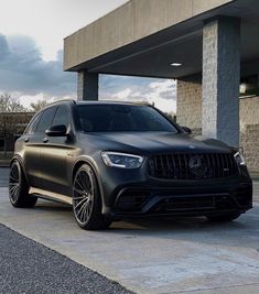 a black mercedes suv parked in front of a building