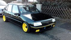 a black car with yellow rims parked on the street