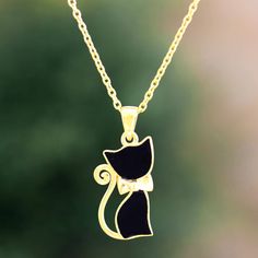 Designed by Sapna Mehta, this adorable pendant necklace is the perfect gift for the cat lover in your life. Indian artisans craft the kitty cat-shaped pendant from 24 gold-plated sterling silver, using glossy enamel to paint the bow-tied critter black. A sleek gold-plated cable chain finishes the necklace with complementary shine. Cat Print Jewelry Gift, Elegant Cat Design Pendant Jewelry, Enamel Cat Design Jewelry For Gift, Cat Design Enamel Jewelry For Gifts, Gift Jewelry With Cat Design In Enamel, Cat Design Pendant Charm Necklaces For Gift, Gold Cat Design Charm Necklace As Gift, Gold Charm Necklace With Cat Design As Gift, Gold Charm Necklace With Cat Design For Gift