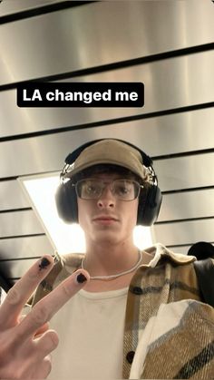 a man wearing headphones and holding his hand up in front of him with the caption la changed me