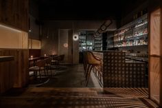 a dimly lit bar with stools and shelves