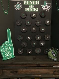 a bunch of buttons and magnets are on a wooden table next to a sign that says punch at the puck