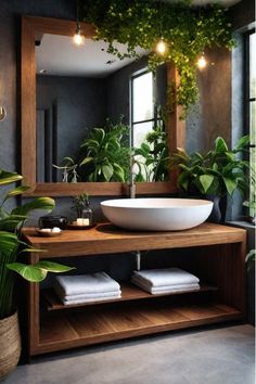 a bathroom sink sitting under a mirror next to plants