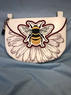 This beautifully embroidered, fully lined crossbody bag with a zipper closure and generous  back pocket. The color/pattern of vegan leather (PU vinyl) and embroidery thread can be customized for no additional costs.  Bee lovers love this bag! The bag and embroidery pattern is from Emfreudery Designs Everyday Leather Shoulder Bag With Embroidered Logo, Leather Shoulder Bag With Embroidered Logo For Everyday Use, Travel Crossbody Bag With Embroidered Logo, Travel Crossbody Shoulder Bag With Embroidered Logo, White Embroidered Satchel Shoulder Bag, Sling Bags, Embroidery Pattern, Honey Bee, Embroidery Thread