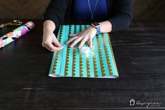 a woman sitting at a table with her hand on top of a piece of paper