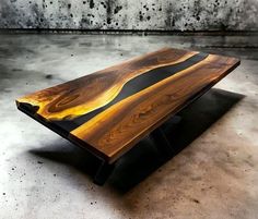 a wooden table sitting on top of a cement floor covered in black and yellow paint