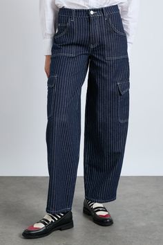 Reintroducing our much loved cargo jeans, reimagined in dark indigo denim with a navy pinstripe. • Popular style • High rise • Wide leg • Cargo side strap detail • Non-stretch indigo denim •Designed in London •100% organic cotton MODEL INFO: Model 1 is 5'10.5 and is wearing a UK 10. Model 2 is 5'9 and is wearing a UK 16. Pinstripe Jeans Outfit, Damson Madder, Folk Clothing, Denim Cargo, Indigo Denim, Fire Fits, Lifestyle Store, Dark Indigo, Denim Design