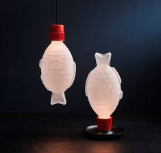 two white glass lamps sitting on top of a wooden table