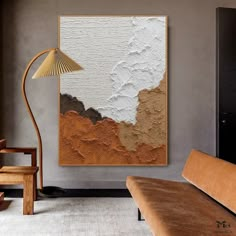 an abstract painting hangs on the wall next to a couch and lamp in a living room