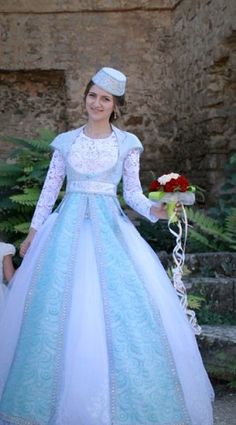 a woman in a blue and white dress holding a bouquet