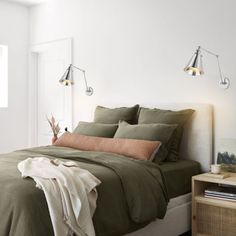 a bed with green sheets and pillows in a bedroom