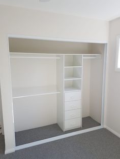 an empty white closet with shelves and drawers