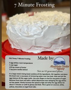 a white frosted cake sitting on top of a red plate next to a sign