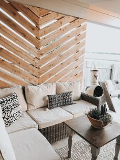 a living room filled with lots of furniture and pillows on top of a rug next to a table