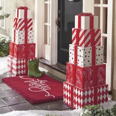 christmas presents are stacked on top of each other in front of a house with snow