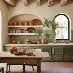 a kitchen with green cabinets and shelves filled with dishes