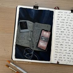 an open book with writing on it next to a pen and cell phone sitting on the page