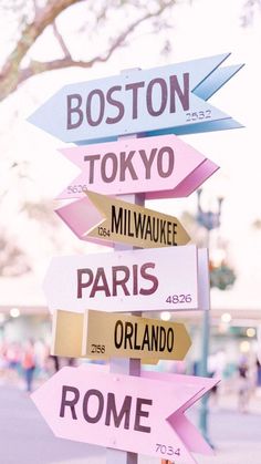 a street sign with many different signs on it's post and the words boston, tokyo, mil - waikeee, paris, or roma