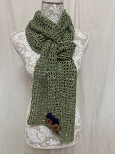 This lovely light olive green scarf has bits of ivory silk throughout the yarn, giving it a texture and softness the photos can't convey. The darling little flowers give it a spring feel....even if Mother Nature may not cooperate, at least you get to add some flowers to your day! At 90" long, this one is super versatile and can be wrapped, knotted, and tied many ways....because it's a light-weight 40% merino, 40% alpaca, 20% silk, it is amazingly soft! All items are created in our smoke-free home with careful attention to quality. I have been crocheting for over 40 years and am happy to chat with you about custom-creating one-of-a-kind afghans, scarves, etc. Note that colors may appear differently on your screen. Green Knitted Scarf One Size, Green Knitted One-size Scarves, One Size Green Shawl For Spring, Handmade Green Shawl For Spring, Green Bohemian Scarf For Spring, Handmade Green Scarf For Winter, Handmade Green Winter Scarf, Handmade Green Winter Scarves, Casual Green Handmade Scarf