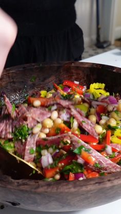 a wooden bowl filled with lots of food