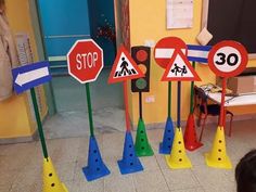 several traffic signs and cones in front of a child's playroom with a girl looking at them