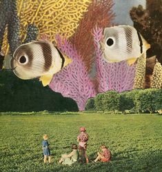 two children are sitting in the grass with fish and corals above them, while another child is standing near by