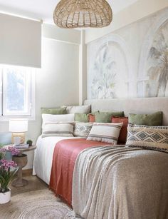 a bedroom with a bed, rugs and paintings on the wall above it's headboard