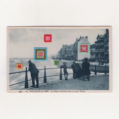 an old photo of people flying kites in the air near the water's edge